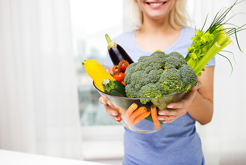 healthy eating, vegetarian food, diet and people concept - close up of woman holding vegetables in bowl