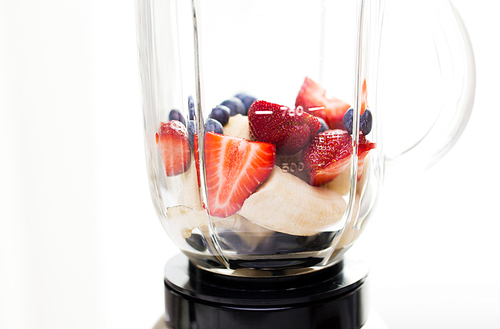 healthy eating, cooking, kitchen appliances and technology concept - close up of blender shaker with fruits and berries