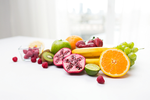 healthy eating, food and diet concept- close up of fresh ripe fruits and berries on table