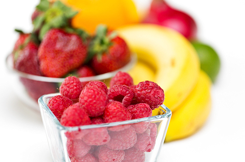 healthy eating, food and  concept - close up of fresh raspberry and fruits on table