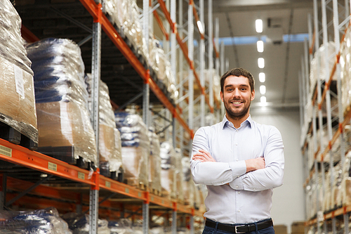 wholesale, logistic, business, export and people concept - happy man at warehouse