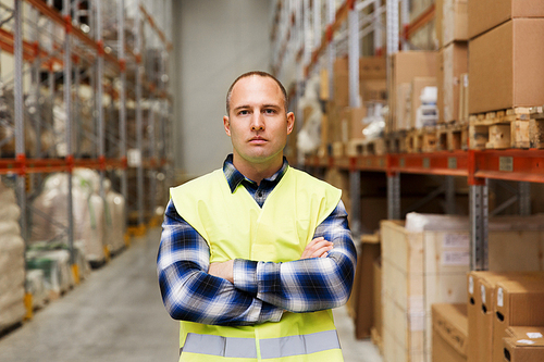 wholesale, logistic, people and export concept - man in reflective safety vest at warehouse