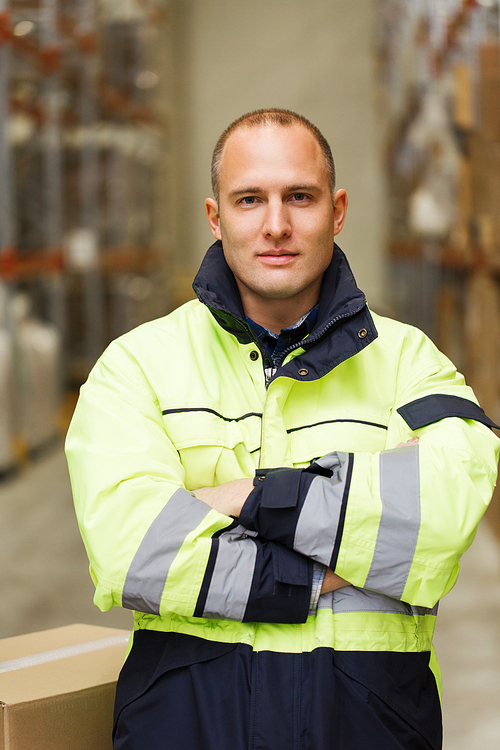 logistic, delivery, shipment, people and export concept - happy man or manual worker in coveralls with boxes at warehouse