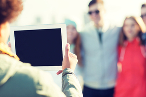 friendship, technology and people concept - close up of african woman with tablet pc computer photographing her happy friends outdoors