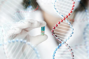 science, chemistry, biology, medicine and people concept - close up of young female scientist or doctor showing pill in laboratory and dna molecule structure