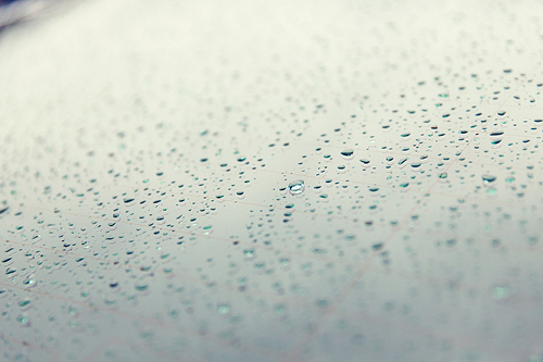 rainy weather and vehicles concept - close up of wet rear car glass