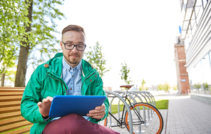 people, style, technology and lifestyle - happy young hipster man with tablet pc computer and fixie bike sitting on bench in city