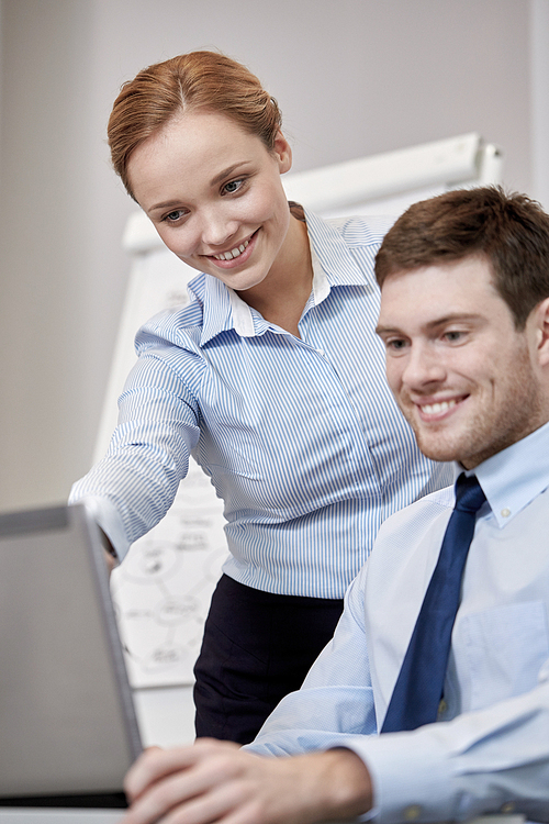 business, people, technology and teamwork concept - smiling businessman and businesswoman with laptop computer meeting and talking in office