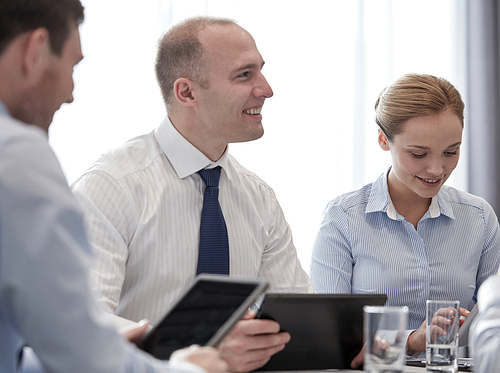 business, conference, people, technology and teamwork concept - smiling businessmen and businesswoman with tablet pc computer meeting in office