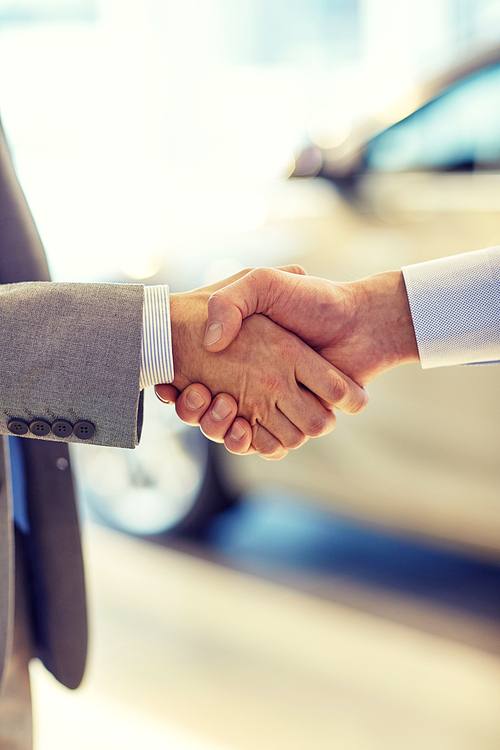 auto business, car sale, deal, gesture and people concept - close up of male handshake in auto show or salon