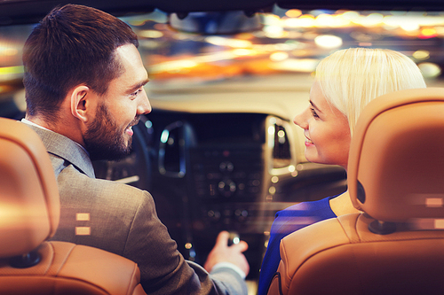 love, luxury, nightlife, automobile  and people concept - happy couple driving in cabriolet car over night city lights background