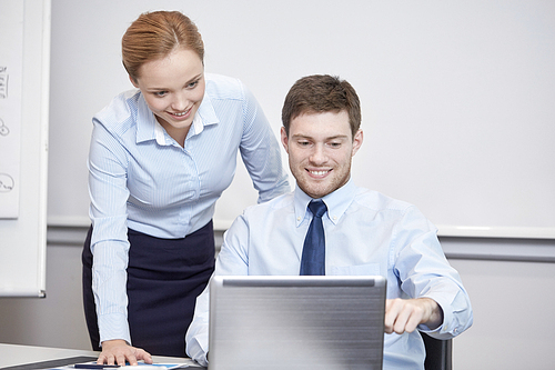 business, people, technology and teamwork concept - smiling businessman and businesswoman with laptop computer meeting and talking in office