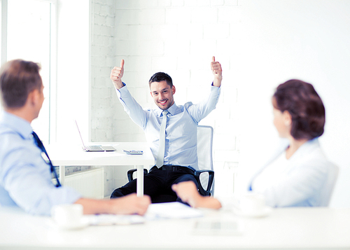 picture of happy businessman showing thumbs up in office