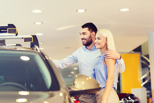 auto business, car sale, consumerism and people concept - happy couple buying car in auto show or salon