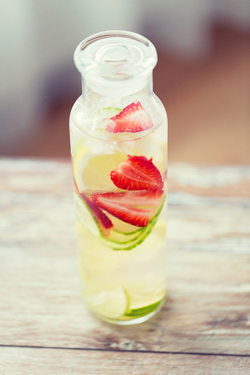 healthy eating, drinks, weight loss and detox concept - close up of fruit water with lime, lemon and cucumber in glass bottle