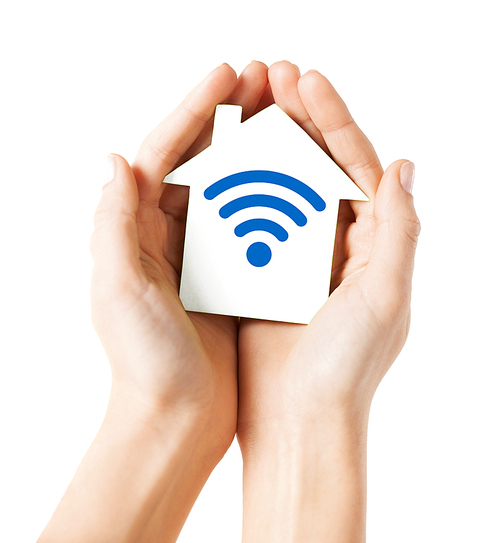 people, internet connection, security, alarm and technology concept - close up of hands holding house with radio or wifi wave signal icon