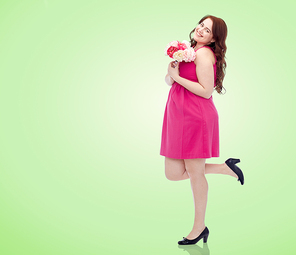 holidays and people concept - smiling happy young plus size woman with flower bunch posing in pink dress over green natural background