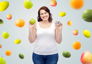 healthy eating, junk food, diet and choice people concept - smiling plus size woman choosing between apple and cookie over gray background with fruits