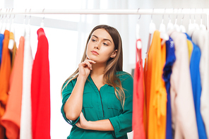 clothing, fashion, style and people concept - woman choosing clothes at home wardrobe