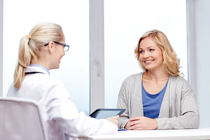 medicine, health care and people concept - smiling doctor with tablet pc computer and woman meeting at hospital
