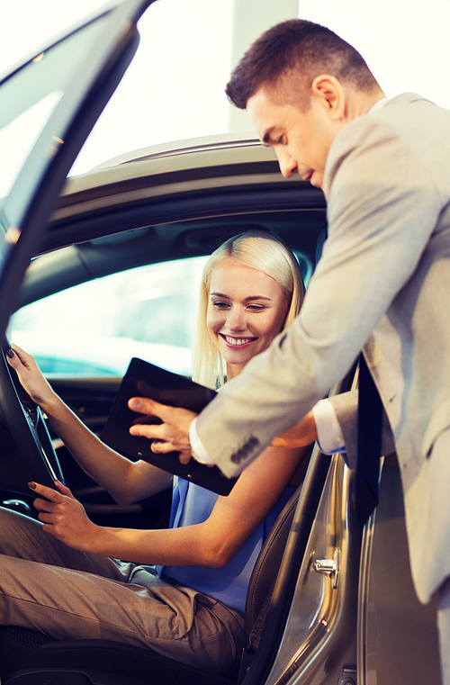 auto business, car sale, consumerism and people concept - happy woman with car dealer in auto show or salon