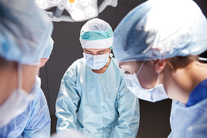 surgery, medicine and people concept - group of surgeons at operation in operating room at hospital
