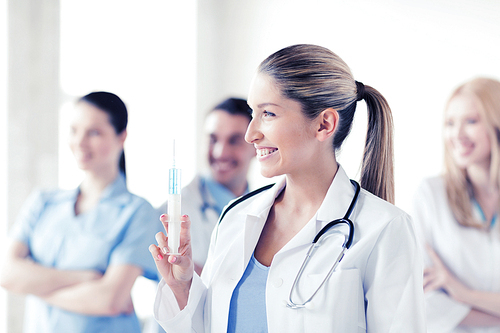 healthcare and medical concept - female doctor holding syringe with injection