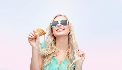 summer, junk food and people concept - young woman or teenage girl in sunglasses eating ice cream over rose quartz and serenity gradient background