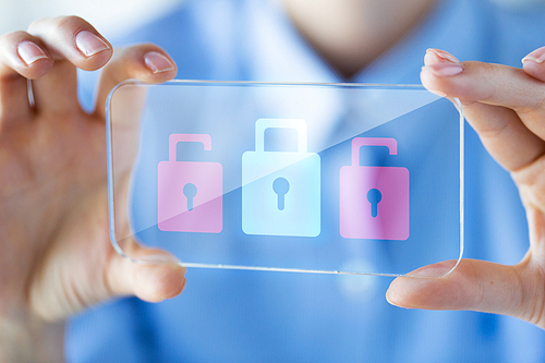 business, technology, safety, security and people concept - close up of woman hand holding and showing transparent smartphone with padlock icons on screen at office