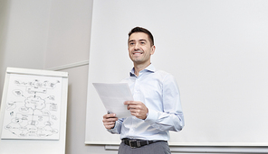 business and people concept - smiling businessman on presentation in office