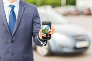 transport, business trip, mass media, technology and people concept - close up of man showing web pages on smartphone screen on car parking