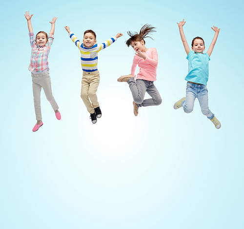 happiness, childhood, freedom, movement and people concept - happy little children jumping in air over blue background