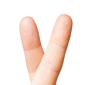 gesture and body parts concept - close up of hand showing two cross fingers