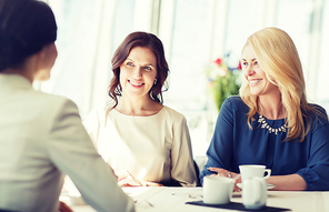 people, communication and lifestyle concept - happy women drinking coffee and talking at restaurant
