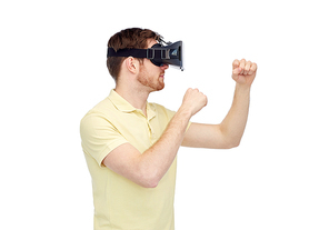 3d technology, virtual reality, entertainment and people concept - young man with virtual reality headset or 3d glasses playing game and fighting
