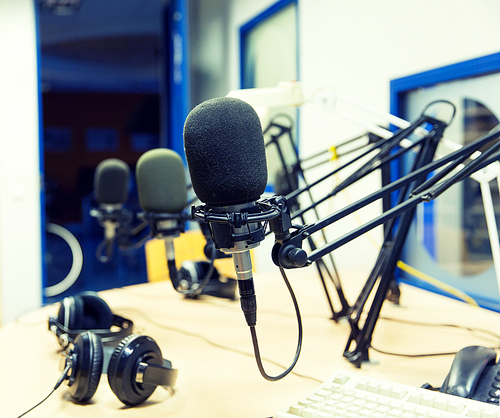 technology, electronics and audio equipment concept - close up of microphone at recording studio or radio station