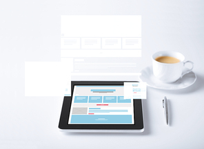 business and technology concept - close up of tablet pc computer with web page design template and cup of coffee