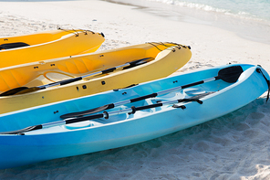kayaking, leisure, water sport and summer vacations concept - canoes or kayaks on sandy beach