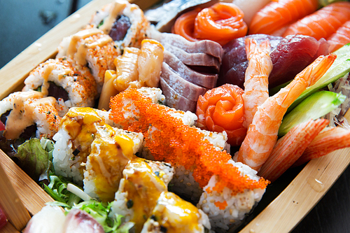 cooking, asian kitchen, seafood, eating and food concept - sushi set at restaurant