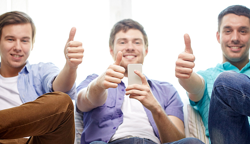 friendship, technology and people concept - close up of happy smiling male friends with smartphones showing thumbs up at home