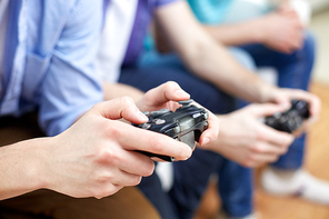 friendship, technology, games and home concept - close up of male friends playing video games at home