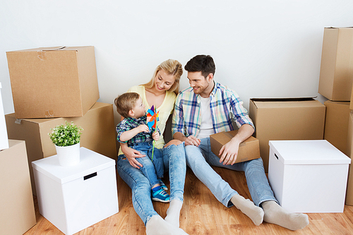 mortgage, people, housing and real estate concept - happy family with boxes moving to new home