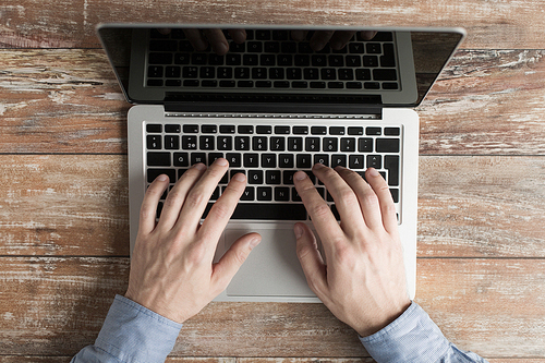 business, education, people and technology concept - close up of male hands with laptop on table