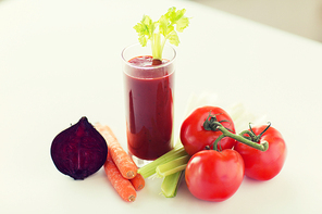 healthy eating, organic food and diet concept - close up of fresh juice glass and vegetables on table