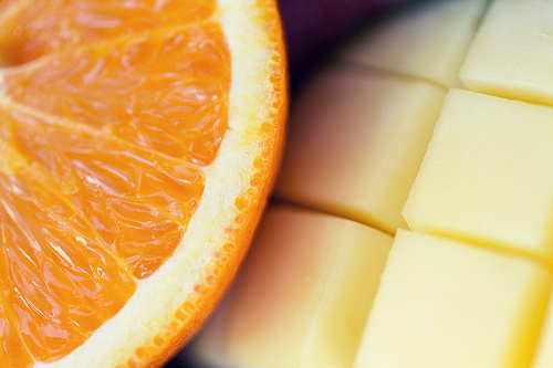 healthy eating, food, fruits and diet concept - close up of fresh juicy orange and mango slices