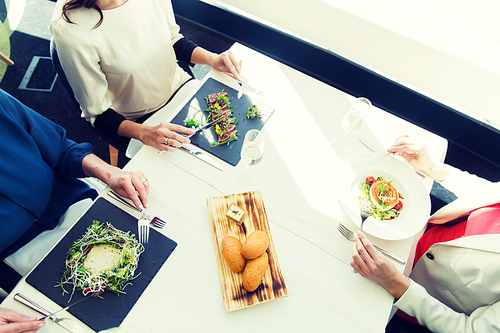 people, holidays, celebration and lifestyle concept - close up of women eating appetizer for dinner at restaurant