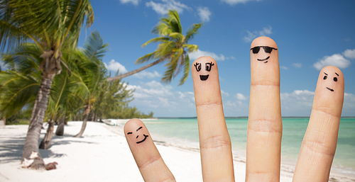 travel, tourism, summer vacation, people and body parts concept - close up of fingers family with smiley faces over exotic tropical beach with palm trees background