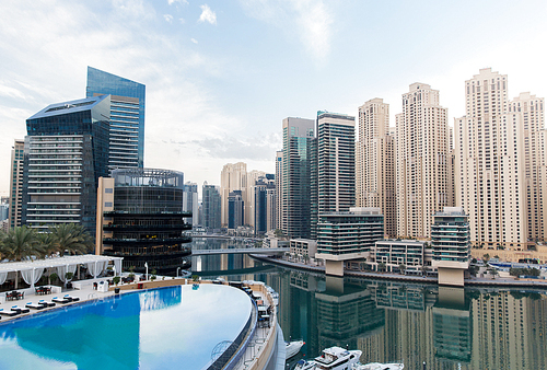 cityscape, travel, tourism and urban concept - Dubai city district skyscrapers and seafront with hotel infinity edge pool