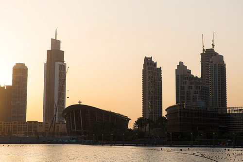 cityscape, travel, tourism and urban concept - Dubai city business district skyscrapers and seafront at evening