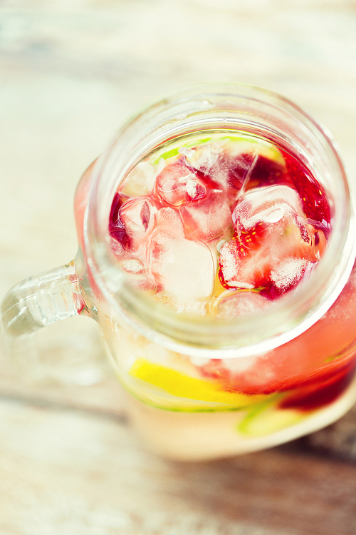 healthy eating, drinks, weight loss and detox concept - close up of fruit water with lime, lemon and cucumber in glass bottle